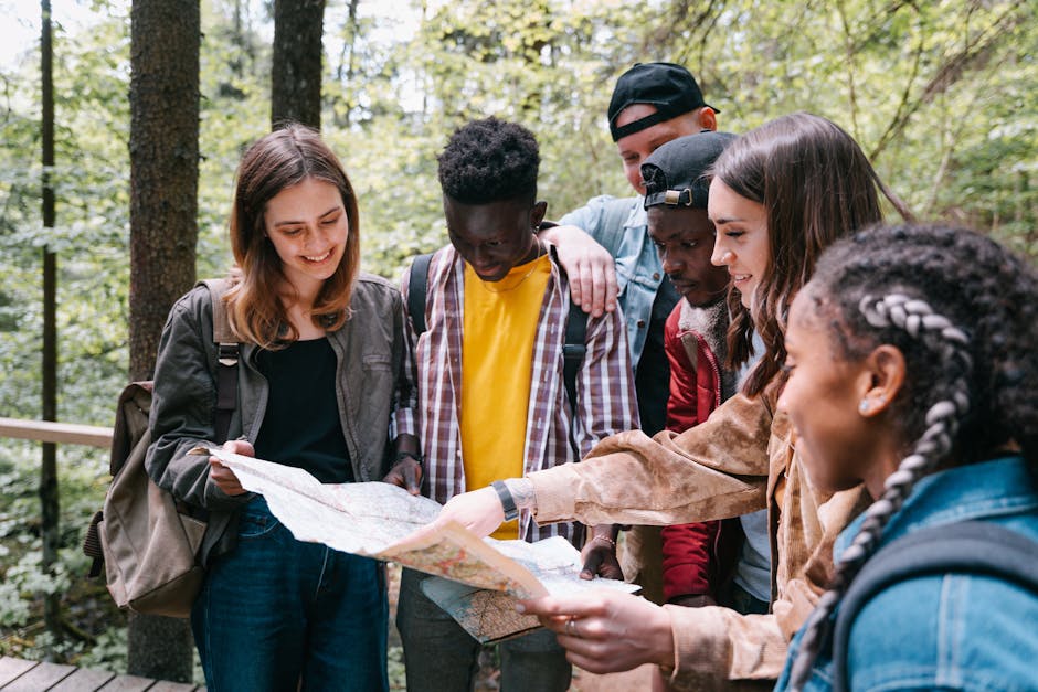 A diverse group of young adults enjoying an outdoor adventure, studying a map together.