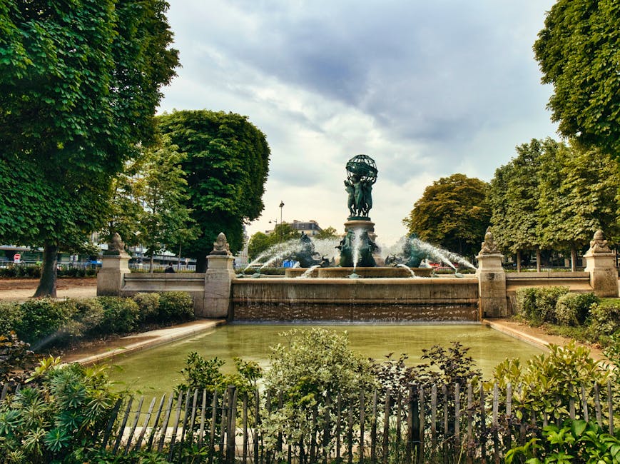 Elegant fountain in Jardin du Luxembourg, Paris, surrounded by lush greenery and vibrant trees.