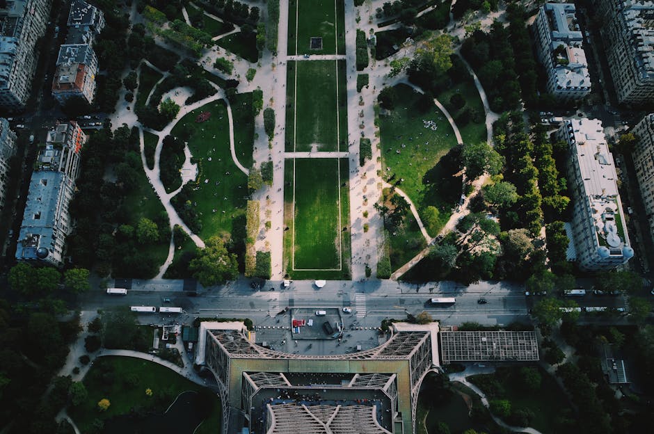 Stunning aerial view of the Eiffel Tower, Paris, showcasing the lush gardens and city streets below.
